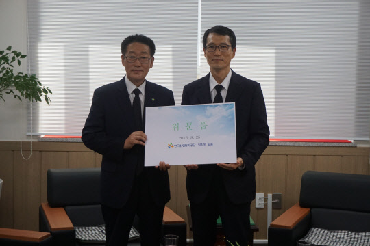 한국산업단지공단 임직원이 25일 을지연습 안보교육의 일환으로 25일 국립영천호국원을 방문해 참배하고 묘역봉사활동을 벌였다. 강남훈 산단공 이사장(오른쪽)이 국가유공자 유족을 위한 위문품도 전달했다. 산단공 제공